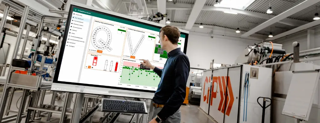 Ein Produktionsmitarbeiter analysiert digitale KPI-Dashboards zur Optimierung des Shopfloor Managements. Die klare Definition von Zielen und eine strukturierte Roadmap sorgen für eine erfolgreiche digitale Transformation in der Fertigung.